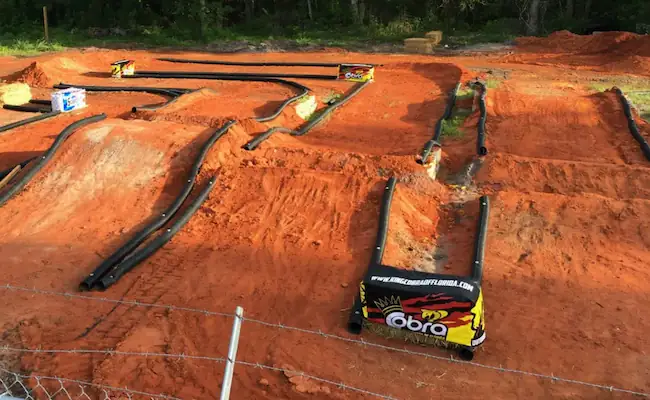 Off-road race track with table-top and double jumps built for competitive RC car racing.